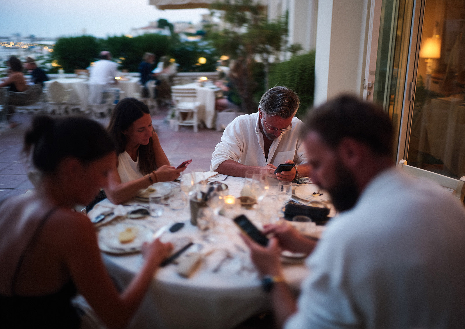 A group at dinner, everyone on their phones
